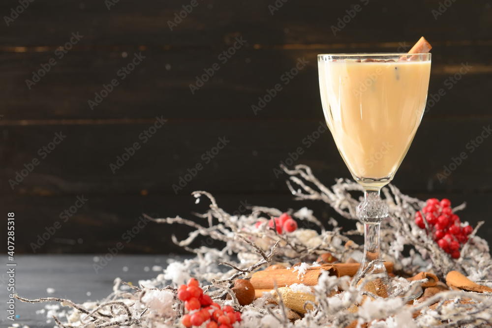 Naklejka premium Tasty milkshake with cinnamon in glass on dark background