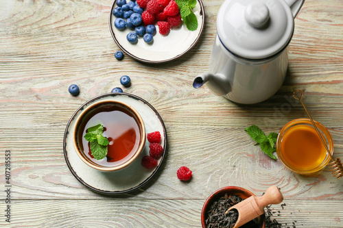 Composition with cup of hot fruit tea on wooden background