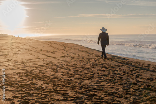 hombre con sombrero caminando hacia el amanecer