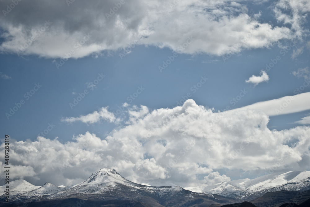 Clouds have accumulated on beautiful snow-capped mountains