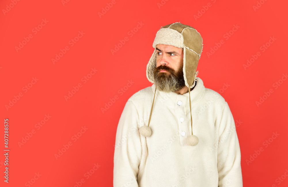 Soft furry accessory. Caring fur garments. Bearded funny hipster. Winter fashion concept. Warm hat for cold weather. Sheep fur. Perfect accessory. Bearded man wear hat with ear flaps red background Soft furry accessory. Caring fur garments. Bearded funny hipster. Winter fashion concept. Warm hat for cold weather. Sheep fur. Perfect accessory. Bearded man wear hat with ear flaps red background