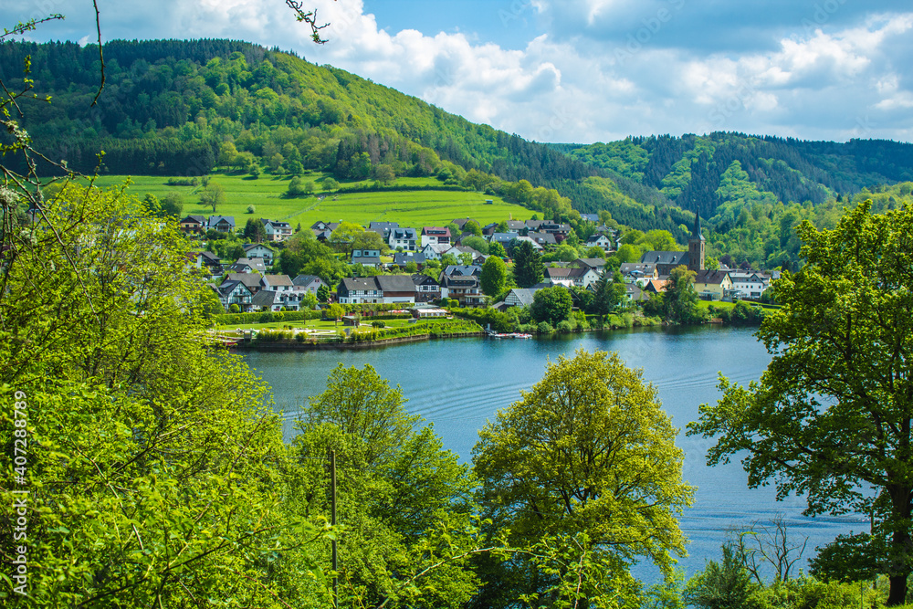 Village Einruhr at Eifel National Park, Germany. Scenic view of lake Rursee and small town in the background