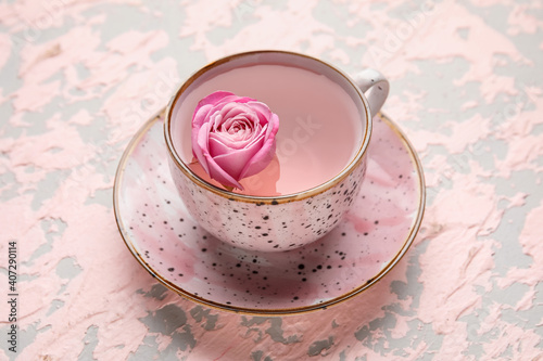 Fototapeta Naklejka Na Ścianę i Meble -  Cup of tea with rose on color background