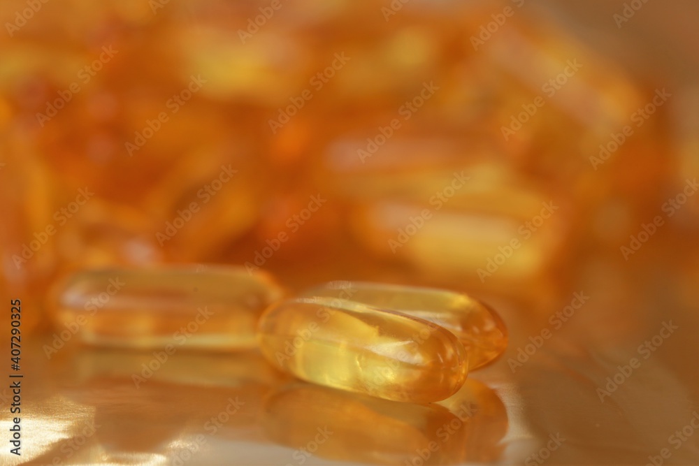 fish oil capsules heap on blurred gold background.Fish oil in gelatin capsules. Omega three.Supplements for a healthy diet. Healthy fats fish oil capsules heap on blurred gold background.Fish oil in gelatin capsules. Omega three.Supplements for a healthy diet. Healthy fats