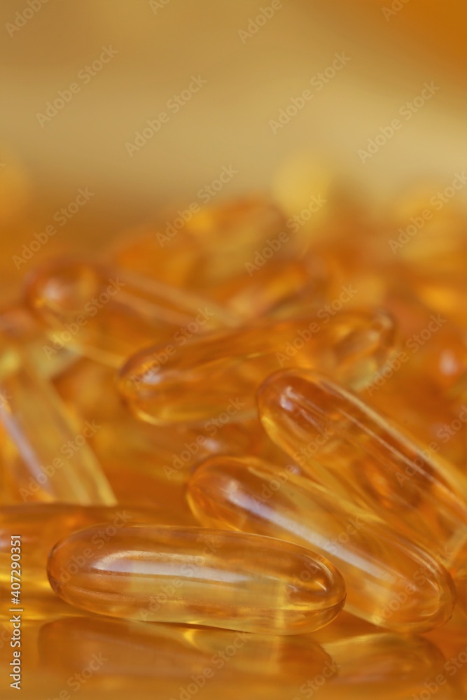 fish oil capsules on blurred gold background.Fish oil in gelatin capsules. Omega three.Supplements for a healthy diet. Healthy fats