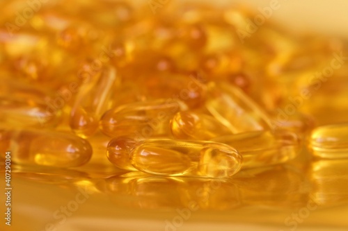 fish oil capsules set on blurred gold background.Fish oil in gelatin capsules. Omega three.Supplements for a healthy diet. Healthy fats