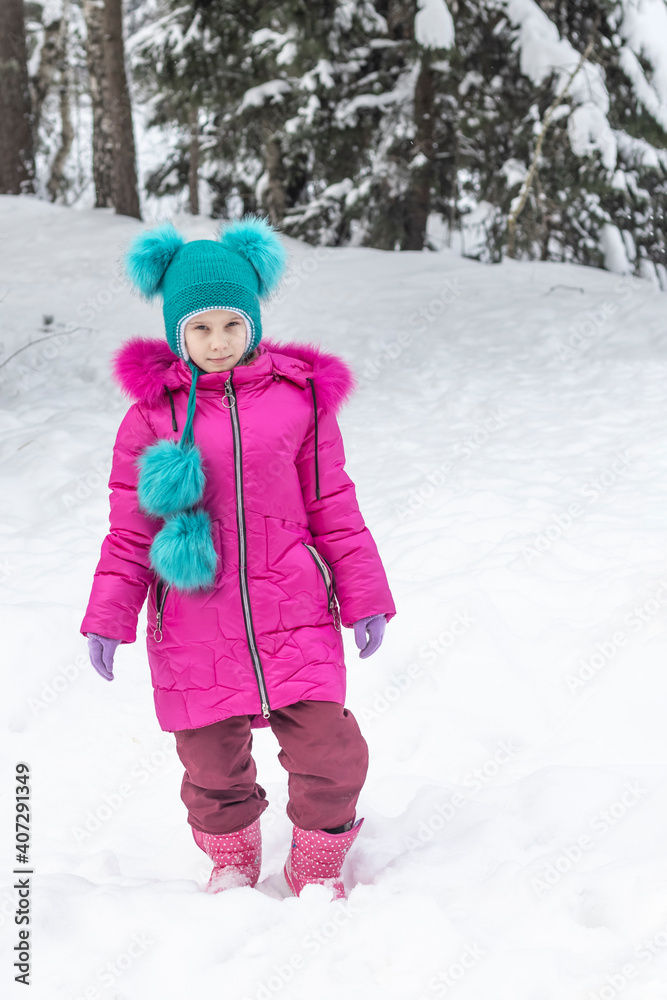 natural light. a girl in a red jacket and a green hat is surrounded by a lot of snow. He looks at us. Soft focus. natural light. a girl in a red jacket and a green hat is surrounded by a lot of snow. He looks at us. Soft focus.