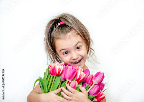 Portrait of a beautiful smiling little girl with spring tulips on a white background. International Women's Day. Girl 5 years old, Caucasian. Isolated.