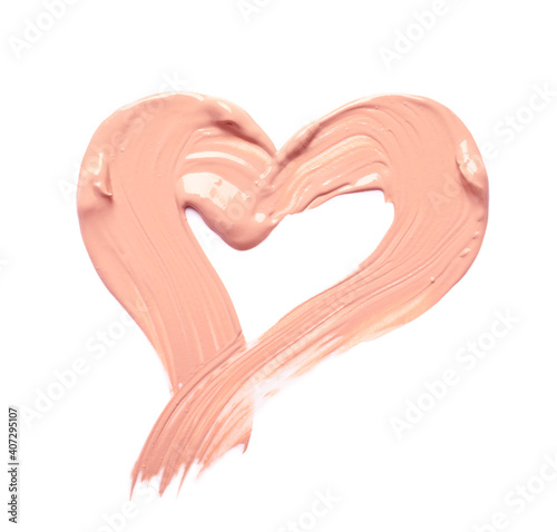 Heart made of makeup foundation on white background photo