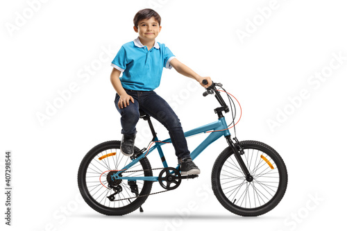 Little boy sitting on a bicycle and looking at the camera