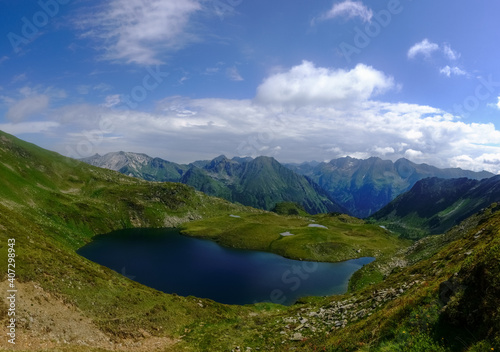 gorgeous blue mountain lake in green hills with little ponds panorama © thomaseder