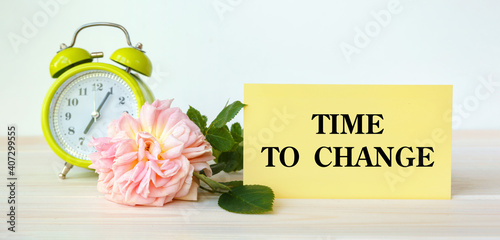 Rose, alarm clock and card for motivational inscription. The inscription Time To Change