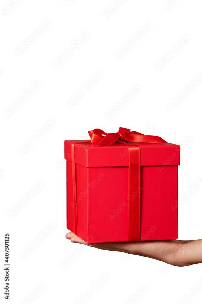 Hand holding red gift box with ribbon bow isolated on white. Holiday concept. Closeup.