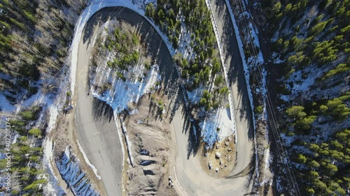 Aerial view of (Flying over) Colorado mountain forest and roads during winter season. 
