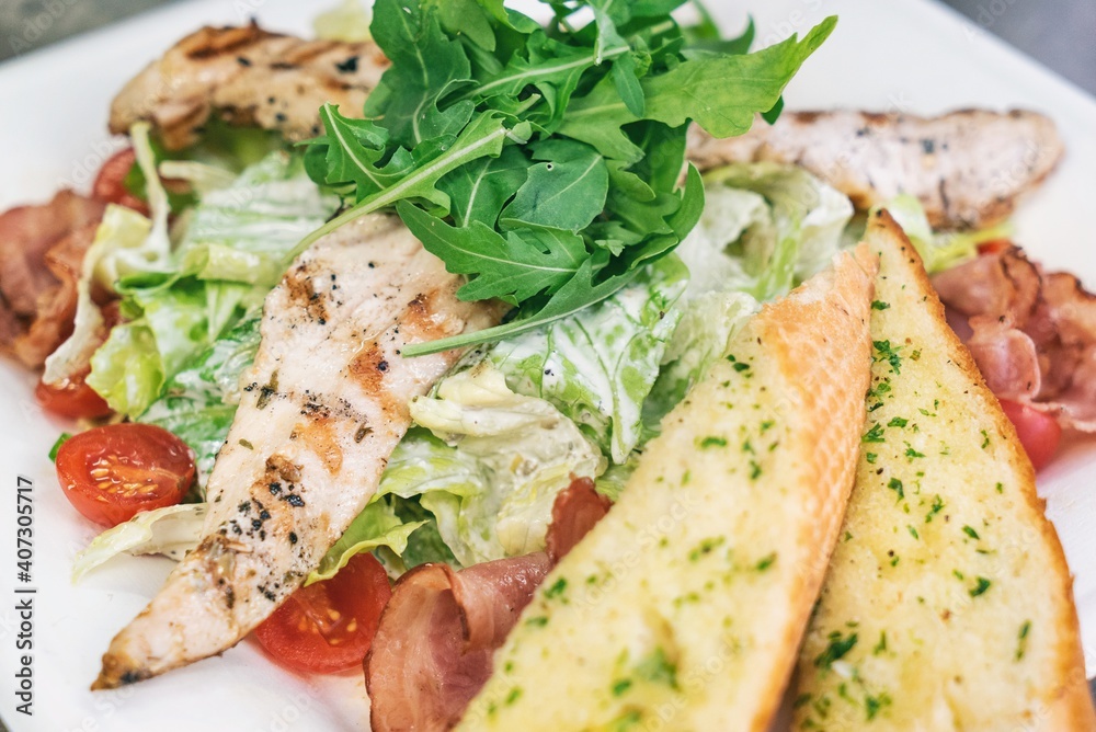 Caesar salad a green salad of romaine lettuce and croutons dressed with lemon juice olive oil, parmesan cheese and chicken. Also called Cesare salad Caesar salad a green salad of romaine lettuce and croutons dressed with lemon juice olive oil, parmesan cheese and chicken. Also called Cesare salad