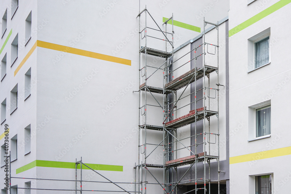 renovation of the facade of an apartment house using scaffolding - obrazy, fototapety, plakaty 
