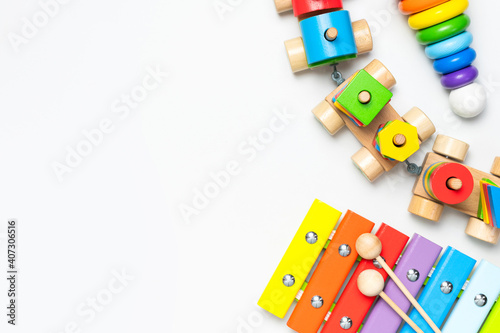 Children's toys made of natural wood on white background. Multi-colored pyramid, train, xylophone in rainbow colors. Eco friendly toy, plastic free. Toy for babies and toddlers. Flat lay top view