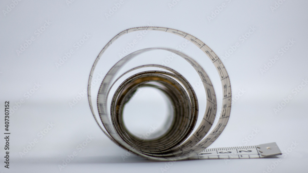 Close up of a two meter long measuring tape. Tape is a spiral. Close up of a two meter long measuring tape. Tape is a spiral.