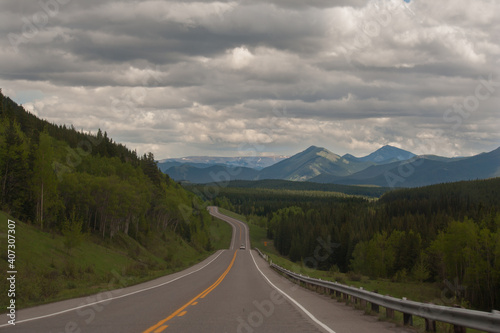 Curving highway following the edge of the Eastern slopes of the Rocky Mountains of Alberta on a moody day