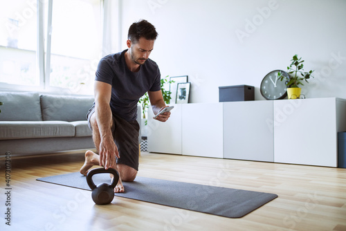 Man setting up online workout app at home photo