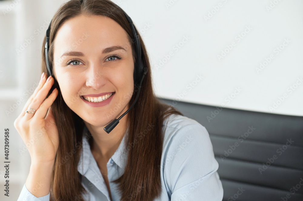 A close-up portrait of young female with a headset wearing formal shirt in the office. Call center, help line, support service A close-up portrait of young female with a headset wearing formal shirt in the office. Call center, help line, support service