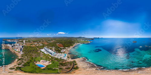 Aerial drone 360 Degree panoramic sphere aerial photo of the beautiful beach front of Ibiza in Spain showing the Spanish beach and hotels from above