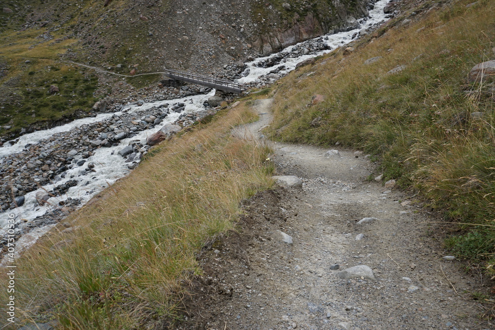 Wanderweg hin zu einer Brücke über einen Gebirgsbach Wanderweg hin zu einer Brücke über einen Gebirgsbach