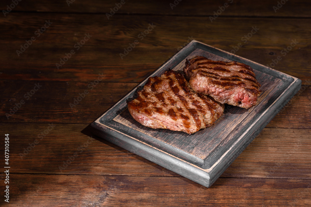 Fresh juicy delicious beef steak on a dark background Fresh juicy delicious beef steak on a dark background