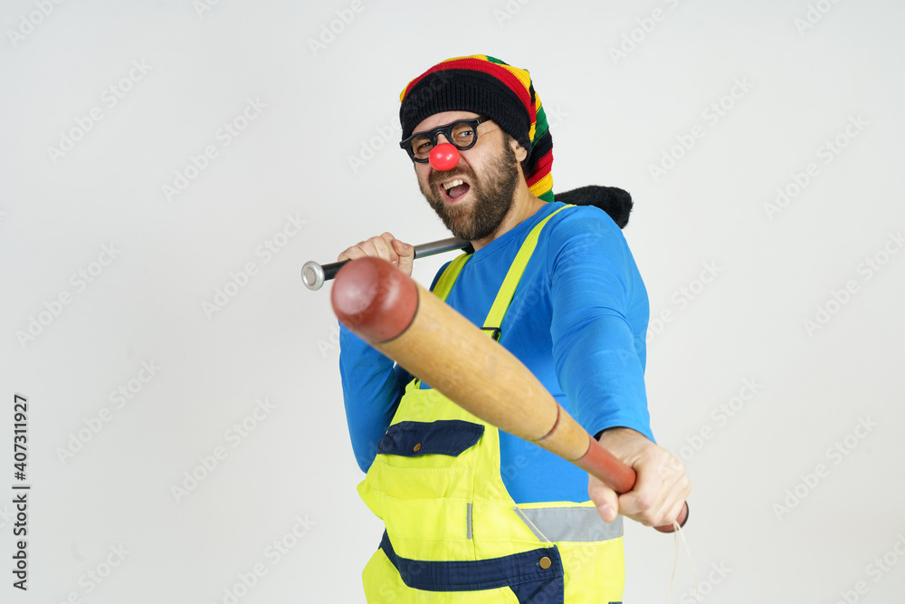 The clown holds baseball bats in his hands. Isolated on white The clown holds baseball bats in his hands. Isolated on white