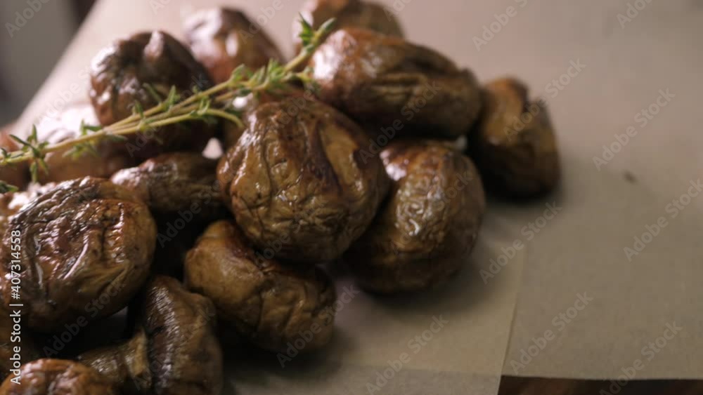 Appetite fried mushrooms with rosemary. Grilled champignons rotate on a wooden board. Appetite fried mushrooms with rosemary. Grilled champignons rotate on a wooden board.