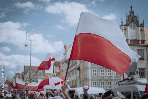 The Polish flag waving over the crowd of people 