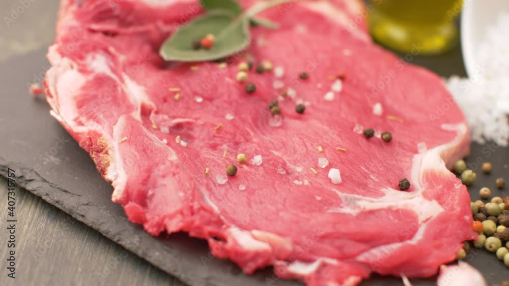 delicious raw steak of rib with salt,pepper and oil on slate plate delicious raw steak of rib with salt,pepper and oil on slate plate