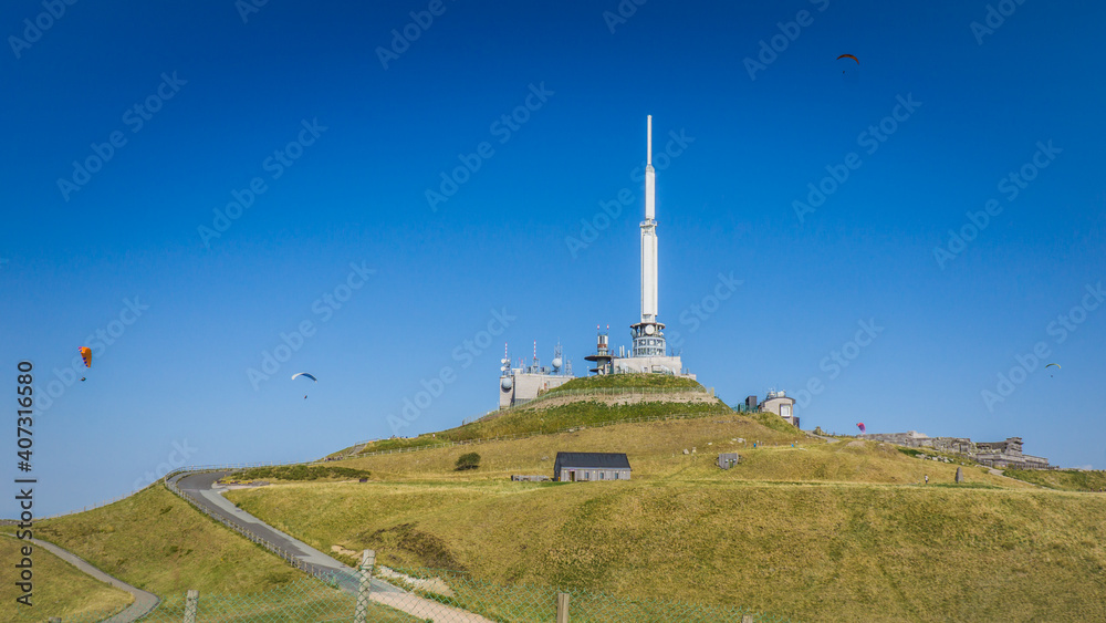Paragliders flying around the Puy de Dome meteorological station in Auvergne, France