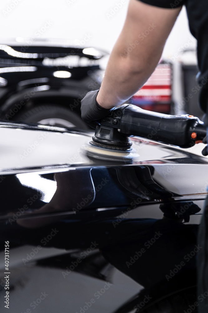 Car detailing studio worker polishing car paint and removing stratches Car detailing studio worker polishing car paint and removing stratches