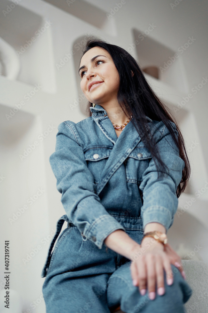great mood. Stylish, bright, modern office. portrait of a brunette woman sitting in a chair in a blue suit. great mood. Stylish, bright, modern office. portrait of a brunette woman sitting in a chair in a blue suit.