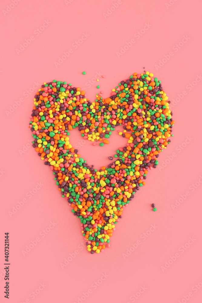 Colorful heart from candy for Valentine's Day on the pink background. Valentine and love concepts.