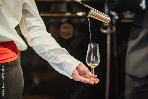 person serving a glass of manzanilla de Jerez, person holding a glass of wine photo