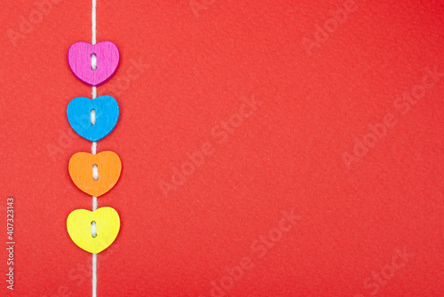Multicolored hearts on a thread on a red background