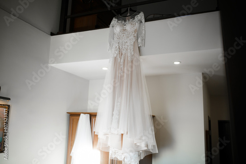 The wedding dress is hanging in the house. Wedding morning.