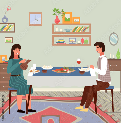People are eating georgian food. Couple is communicating together about Caucasian traditions. Table with khinkali and adjarian khachapuri. People are having a dinner at home. Girl pouring wine
