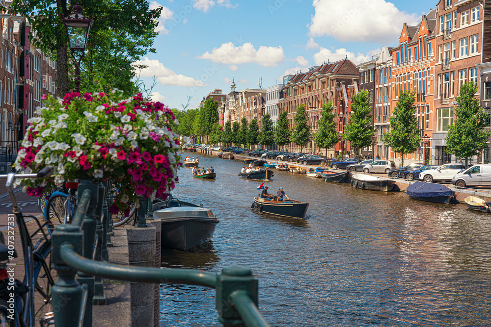 dutch canal with colorful boats  and flowers in summer