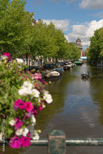 canal in amsterdam with flowerws and boats in summer