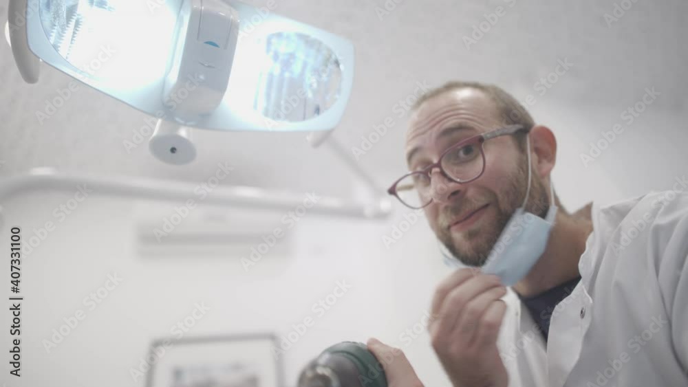 Scary crazy Dentist doctor looking down on the patient and slowly moving an electric drill towards his face. Horror doctor using sharp dangerous tools to fix patient health issues. POV