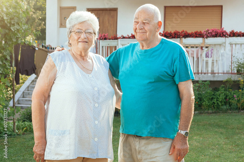 Elderly couple posing for photo in yard