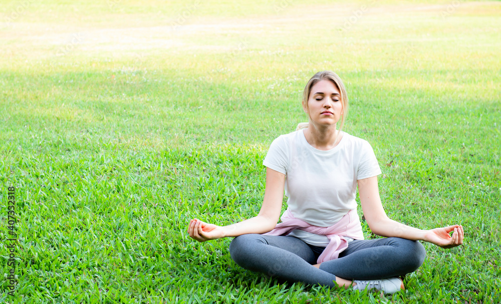 Woman sitting in lotus position closed eyes do meditation breathing technique outdoors, keep calm, healthy life habits and lifestyle concept. Beautiful sporty practicing yoga doing lotus pose.