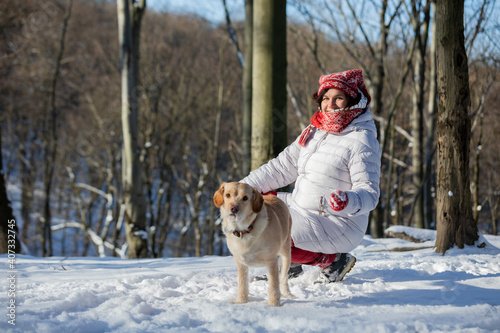 Fototapeta Naklejka Na Ścianę i Meble -  girl playing with a dog in the sunny winter forest