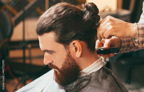 Photo of man at barber shop making an haircut.