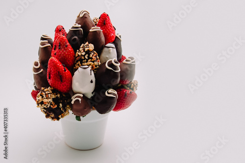 A bundle of edible flowers, arrangement of strawberries covered with chocolate for birthdays, valentine's day, anniversary, special occasions and special days isolated on white with copy space