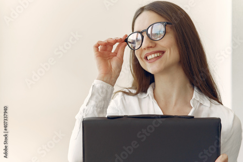 Girl in a office. Woman in a white shirt. Lady use the laptop.