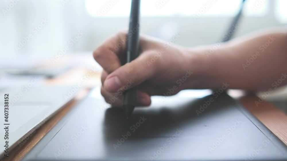 Creative designer Asian woman close up hand using stylus drawing sketching UI UX ideas project design on notebook and laptop, computer slow motion busy working at home modern office desk workspace.